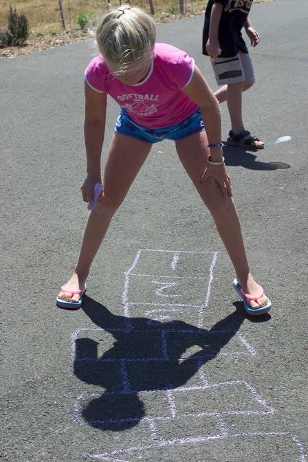 Sara plays hopscotch on the board she drew