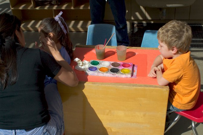 Timothy waits while Darlene paints someone else's face