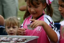 Raquel eyes the cupcakes while Kelsey takes one