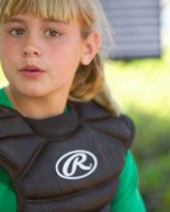 Jennifer putting on her catcher's equipment