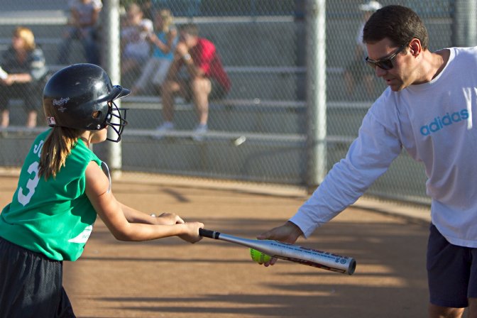 Joel helps Kelsey tune up her swing before batting