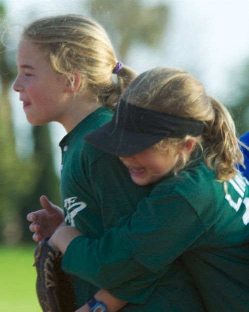Lindsay hugs her twin at the end of the inning