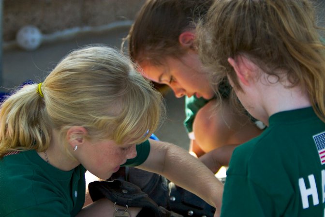 Annie gets some help with the catcher's uniform
