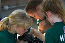 Annie gets some help with the catcher's uniform