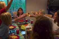 The girls toast each other (with real toast) at dinner