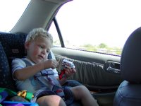 Timothy plays with trucks in the back seat