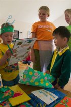 Timothy opens a dinosaur book from Daniel