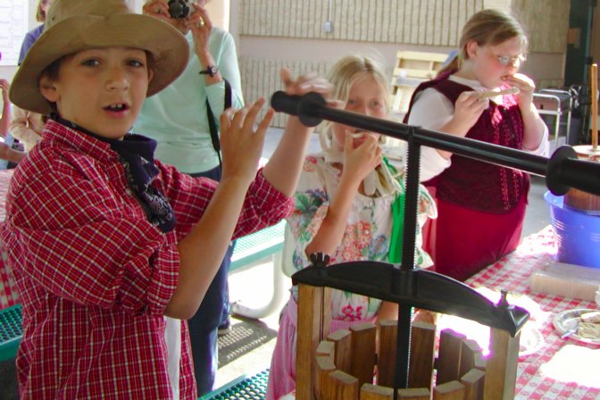 Allen presses apple juice while Sara and Lee try samples of butter