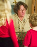 Phyllis opens a present as the kids watch